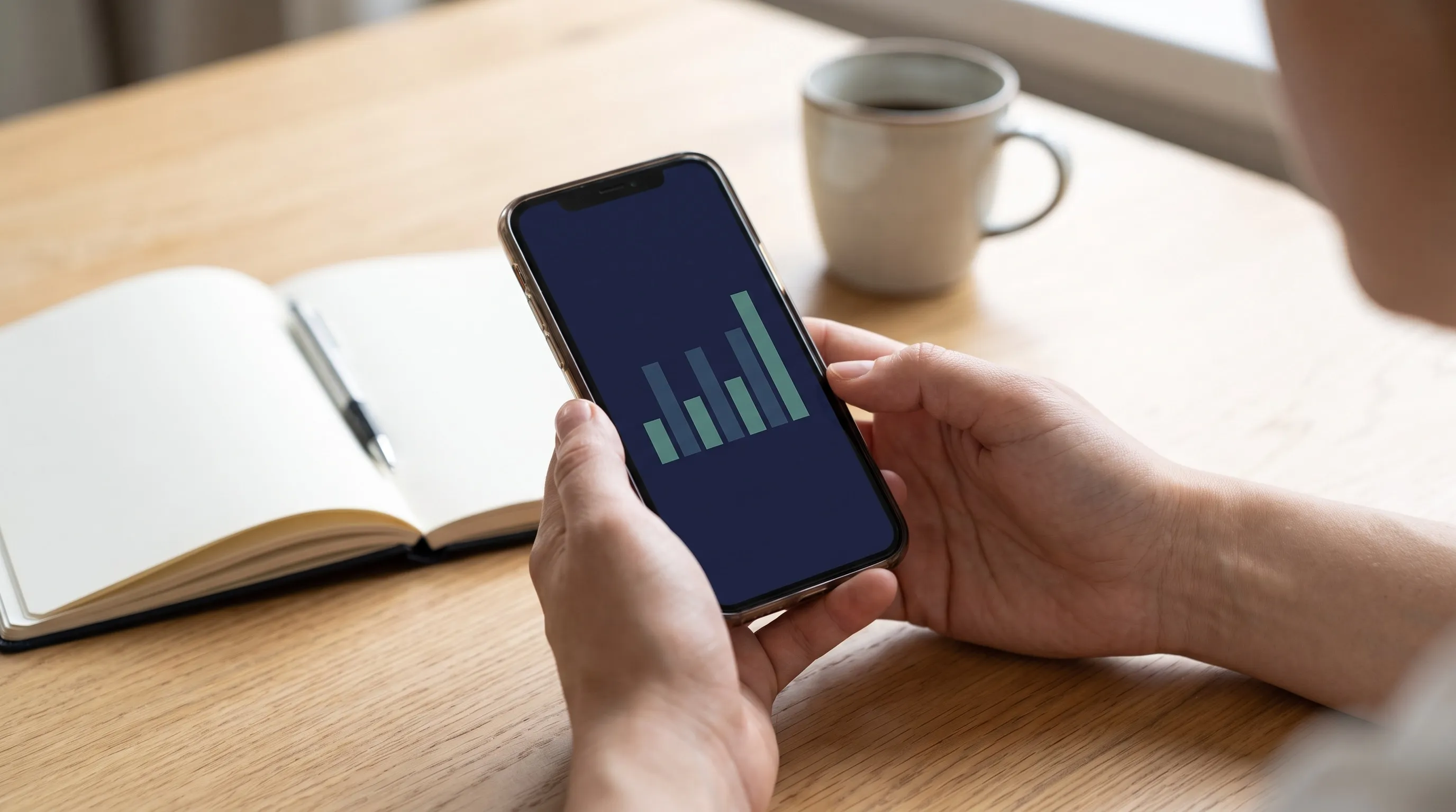 Des mains tiennent un téléphone affichant un graphique